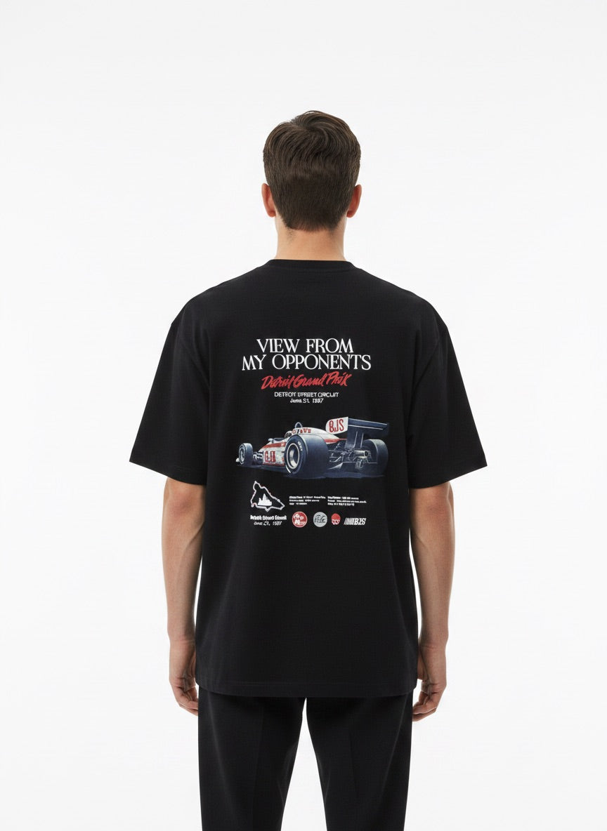 Person wearing a white t-shirt with a racing car graphic and text on the back