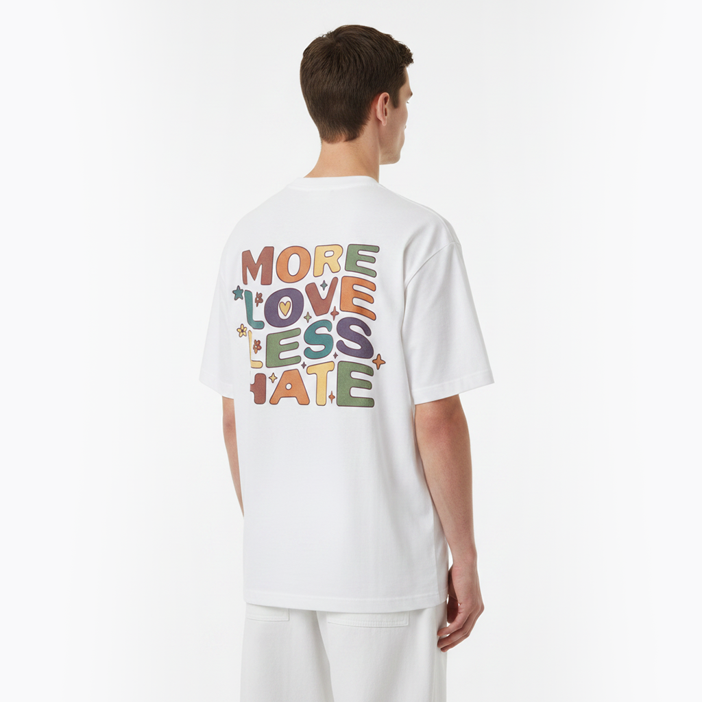 Person wearing a white t-shirt with colorful text on the back, standing against a plain background