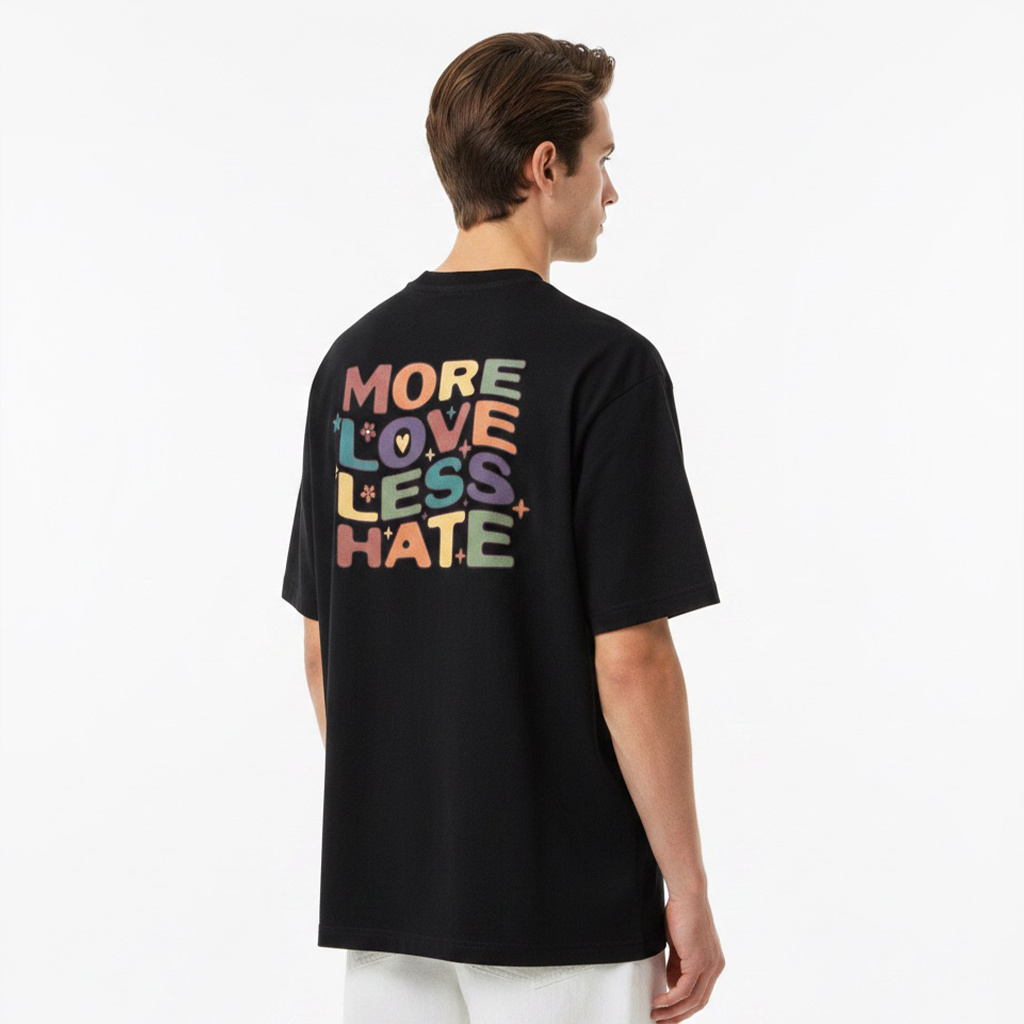 Person wearing a white t-shirt with colorful text on the back, standing against a plain background