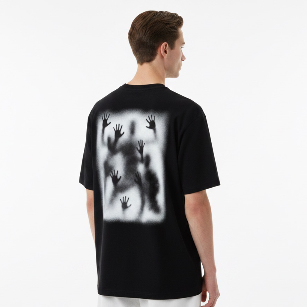 Person wearing a white t-shirt with black handprints on the back against a plain background