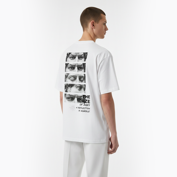 Person wearing a white t-shirt with graphic design on the back against a white background