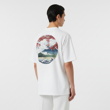 Person wearing a white t-shirt with a colorful graphic on the back against a plain background