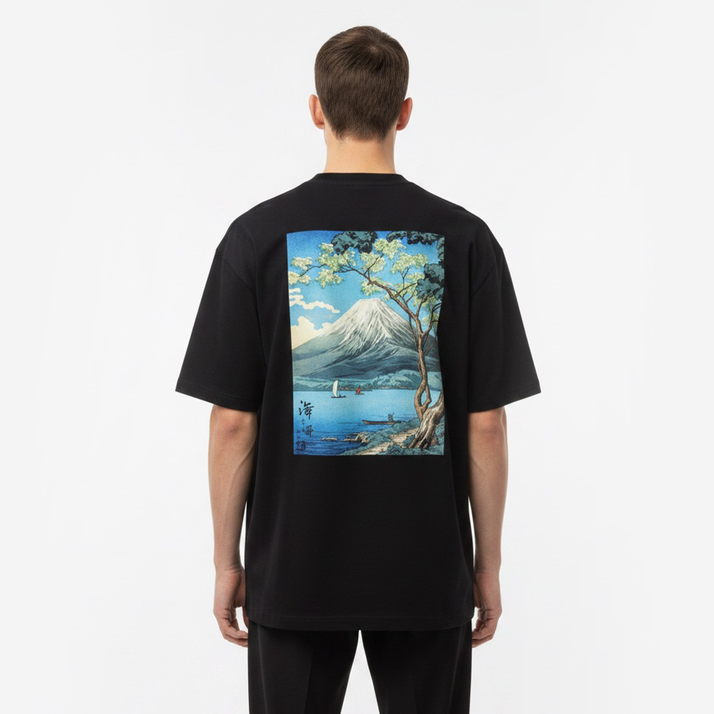 Person wearing a white t-shirt with a scenic graphic on the back, standing against a plain background.