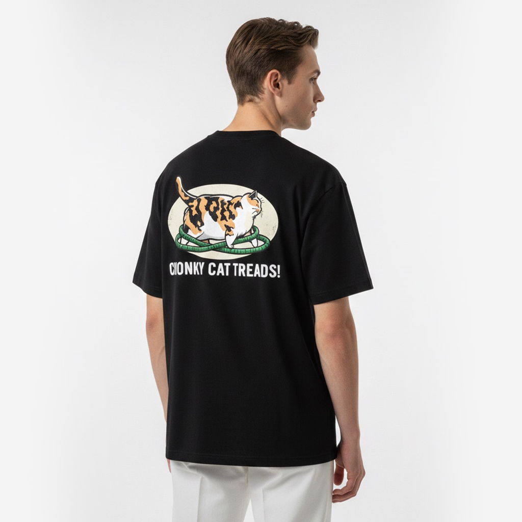 Person wearing a white t-shirt with a cat graphic and text on the back, standing against a white background.
