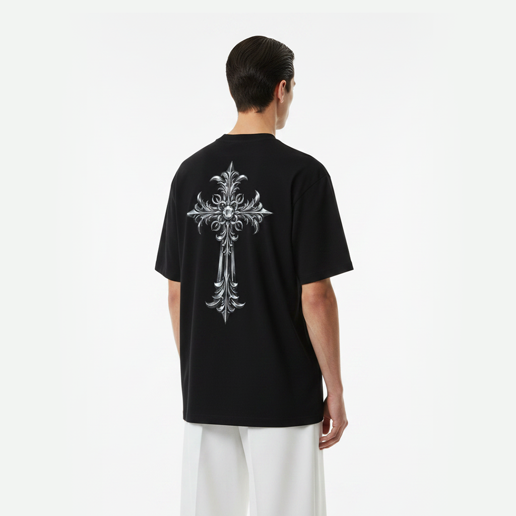 Person wearing a black t-shirt with a silver floral cross design on the back, standing against a white background.